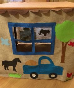 a child's play house made out of felt with animals and trees on it