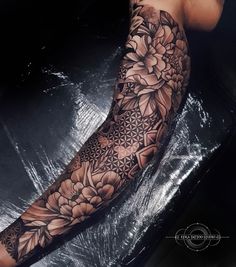 a woman's arm with flowers on it and an intricate design in the middle