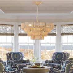 a living room filled with furniture and a chandelier hanging over the top of a table