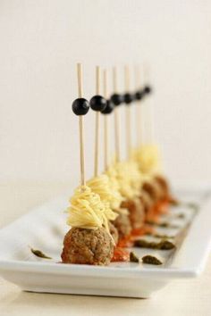 several skewered food items on a white plate