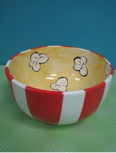 a red and white striped bowl with cartoon mouses on it sitting on a table