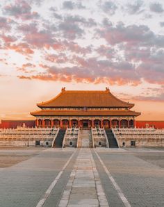 the sun is setting over an ornate building with steps leading up to it's entrance