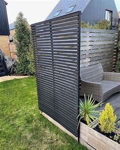 an outdoor living area with a chair and planter in the foreground, surrounded by green grass