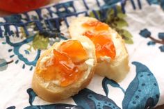 two pieces of bread with jelly on them sitting on a blue and white table cloth