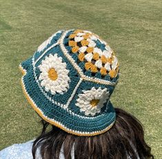 a woman wearing a crocheted hat with flowers on it