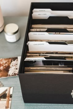 an open file cabinet filled with files on top of a table