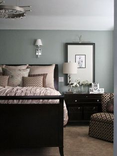 a bed room with a neatly made bed next to a night stand and two chairs