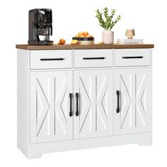 a white cabinet with two doors and three drawers on top of it, next to a coffee maker