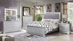 a bedroom scene with focus on the bed, dressers and mirror cabinetry in the background