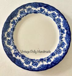 a blue and white plate sitting on top of a table with the words vintage dolly handmade