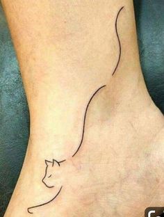 a cat's head is shown on the foot of a person with a small tattoo