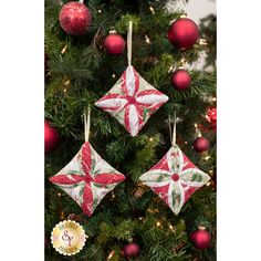 three christmas ornaments hanging from a tree in front of a red and white ornament