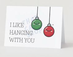 a card with two christmas ornaments hanging from it's strings and the words, i like hanging with you