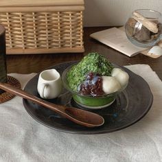 a bowl filled with food sitting on top of a table next to a wooden spoon