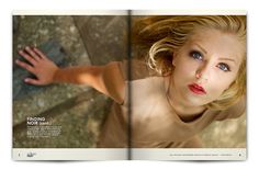 a woman with blue eyes and blonde hair posing for a photo book spread in front of her