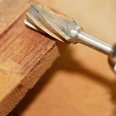 a piece of wood being worked on with a small metal object in the middle of it