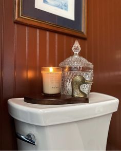 a candle is sitting on top of a toilet