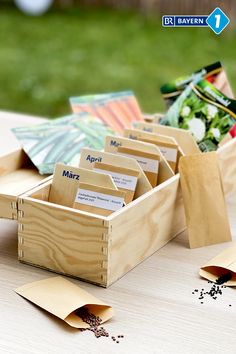 a wooden box filled with lots of different types of cards and papers on top of a table