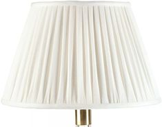 a white lamp with a gold base and a white shade on the top of it