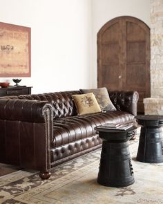 a brown leather couch sitting on top of a rug