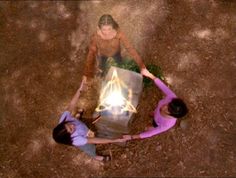 three people standing in the middle of a field with a lightening effect on it