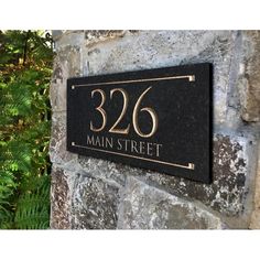 the address plaque is mounted on a stone wall