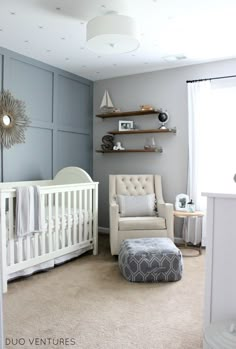 a baby's room with blue walls and white furniture