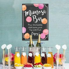 a table topped with lots of drinks next to bottles of juice and cups filled with fruit