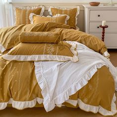 a bed with yellow and white comforters in a room