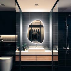 a bathroom with a sink, mirror and shower stall in black tile wallpapered walls