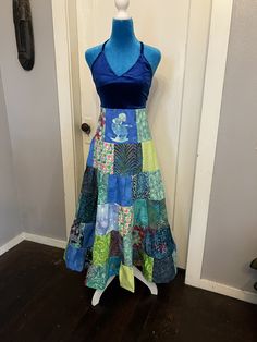 a dress made out of patchwork material sitting on a mannequin