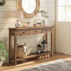 a wooden table sitting in front of a mirror on top of a hard wood floor