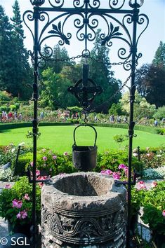 an iron water fountain in the middle of a garden