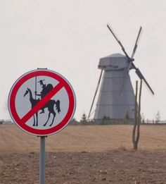 a sign with a windmill in the background that says, calling all unrealistic dreamers and tiltters at windmills we need you