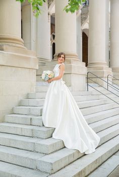 a woman in a wedding dress standing on some steps