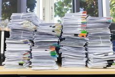 a stack of papers sitting on top of a desk