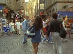 people are walking down the street in an old city