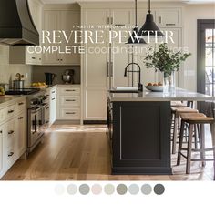 an image of a kitchen with white cabinets and black island in the center, surrounded by wood flooring