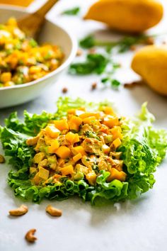 lettuce and mango salad on a white surface