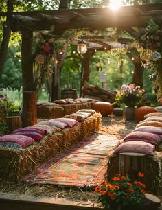 an outdoor seating area with hay and pillows