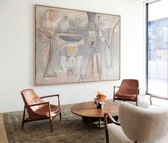 a living room filled with furniture and a painting on the wall