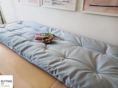 a bed that has some books on it in front of two pictures hanging on the wall