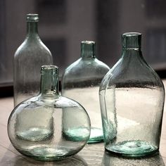 three empty glass bottles sitting on top of a table