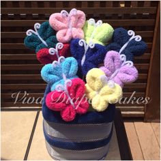 a blue suitcase filled with lots of colorful crocheted flowers