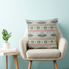 a chair with a pillow on it next to a potted plant and a table