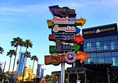 a street sign in front of a building with many different signs on it's sides