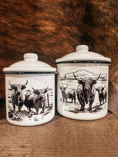 two ceramic containers with black and white images on them, one has a brown cow in the background