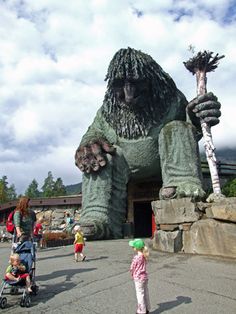 a large statue of a giant gorilla holding a baby in a stroller next to it