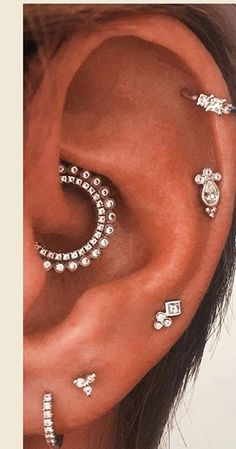 a woman's ear with multiple piercings on her left side and two smaller ones in the middle