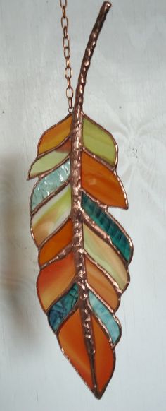 a colorful leaf is hanging from a chain